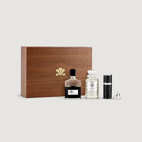 Perfume bottles and wooden box with a brand logo on a light gray background