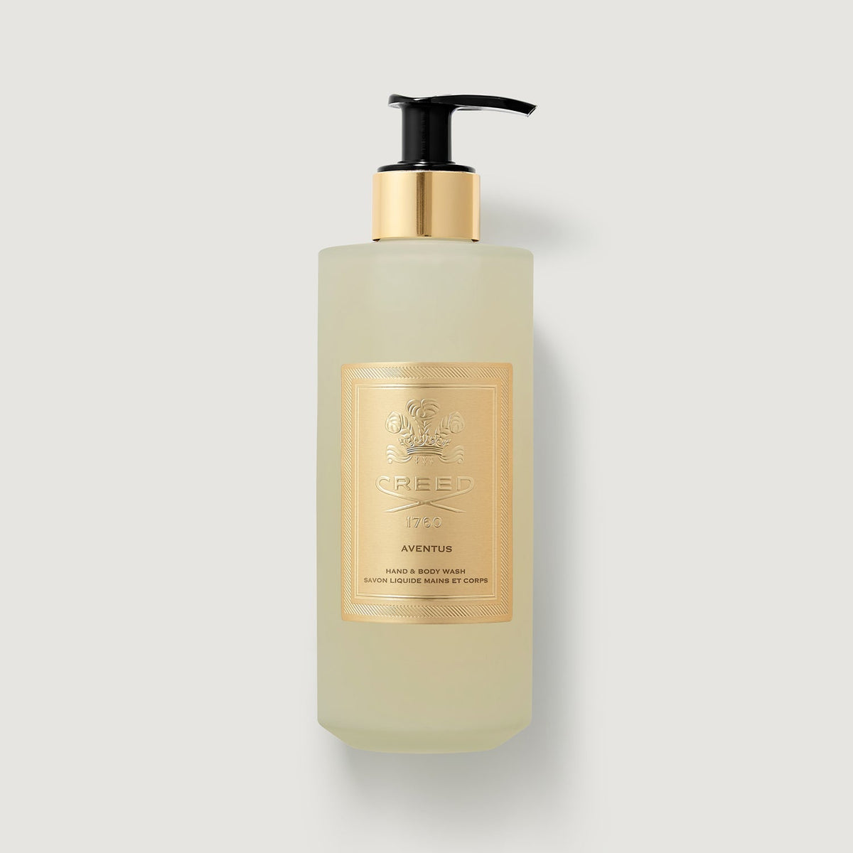 Lotion bottle with gold label on a light gray background