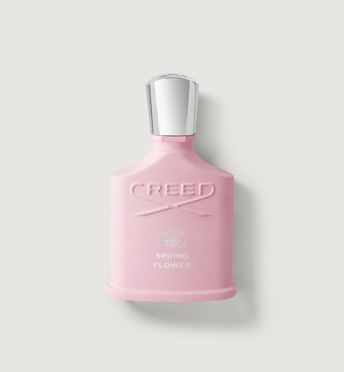 Pink Creed perfume bottle on a light gray background