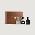Three Creed perfume bottles with a wooden box on a light gray background