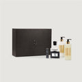 Set of Creed beauty products including a black box, bottles, and a small bottle on a light gray background