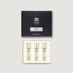 Creed Aventus perfume set with three bottles and a black box on a light gray background